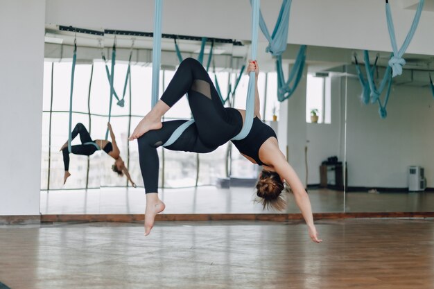 Ragazza abbastanza attraente che fa yoga in una stanza luminosa