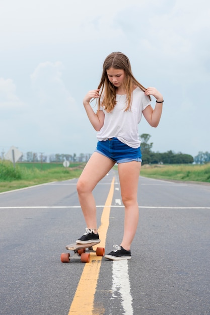 Ragazza abbastanza moderna che staking sulla strada vuota