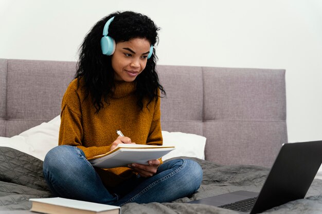 Ragazza adolescente di smiley utilizzando laptop per la scuola in linea