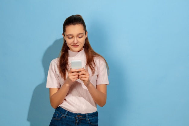 Ragazza adolescente sorridente, utilizza lo smartphone