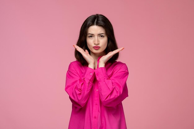 Ragazza adorabile adorabile signora con rossetto rosso in camicia rosa che fa la faccia buffa