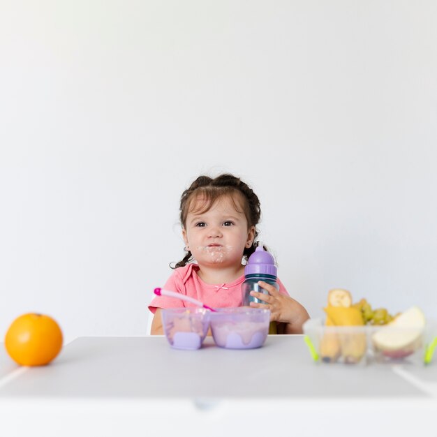 Ragazza adorabile di vista frontale che mangia prima colazione