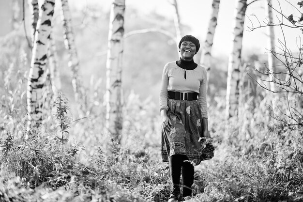 Ragazza afroamericana in abito giallo e rosso al parco autunnale dorato