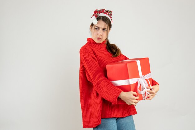 Ragazza agitata vista frontale con il cappello della Santa che nasconde il suo regalo