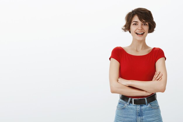 Ragazza alla moda allegra che sorride felice alla macchina fotografica