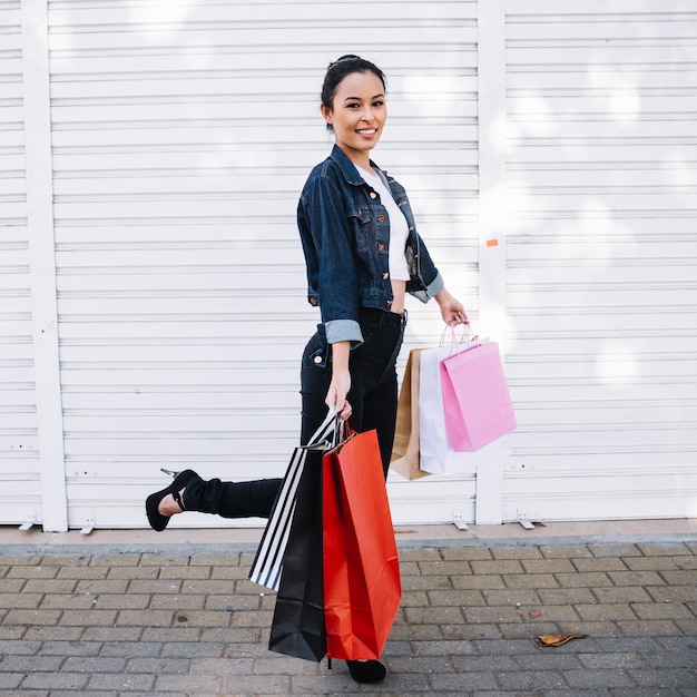 Ragazza alla moda con borse in strada