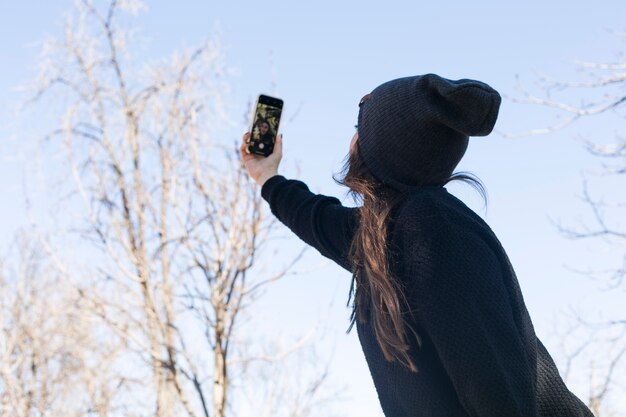 Ragazza alla moda prendendo selfie in strada