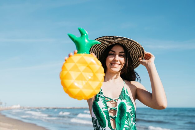 Ragazza allegra con ananas gonfiabile