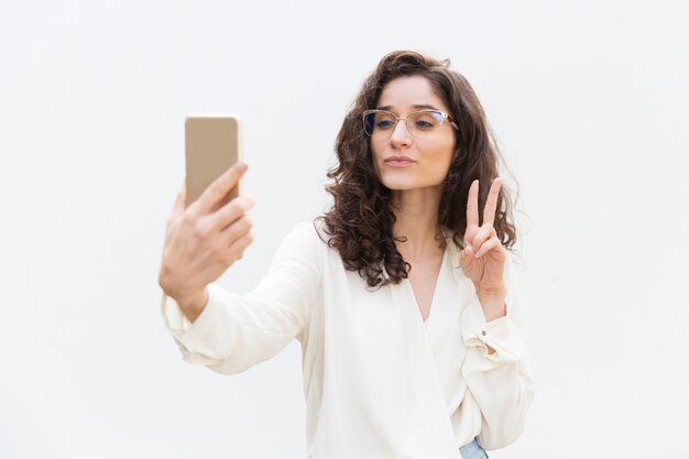 Ragazza allegra della donna che prende selfie sullo smartphone