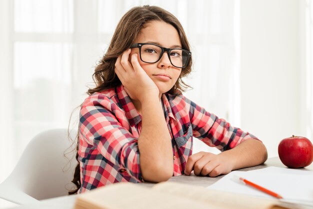 Ragazza annoiata dell'angolo alto mentre studiando