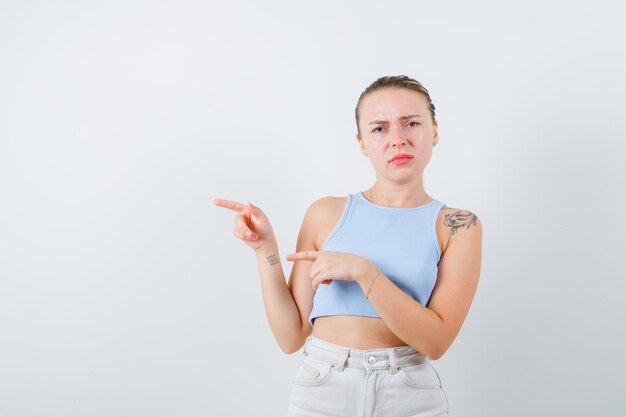 ragazza annoiata sta mostrando qualcosa su sfondo bianco