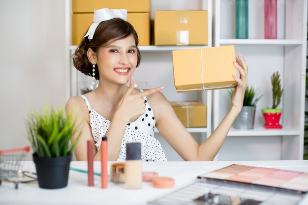 Ragazza asiatica che lavora a casa ufficio e che ordina la cassetta della posta del pacchetto al servizio di consegna al cliente