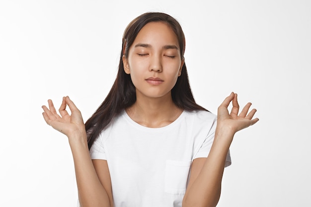 Ragazza asiatica espressiva che propone dell'interno