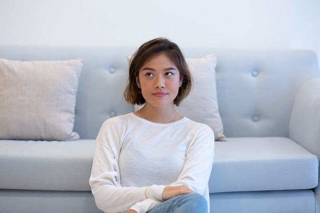 Ragazza asiatica Pensive che posa a casa