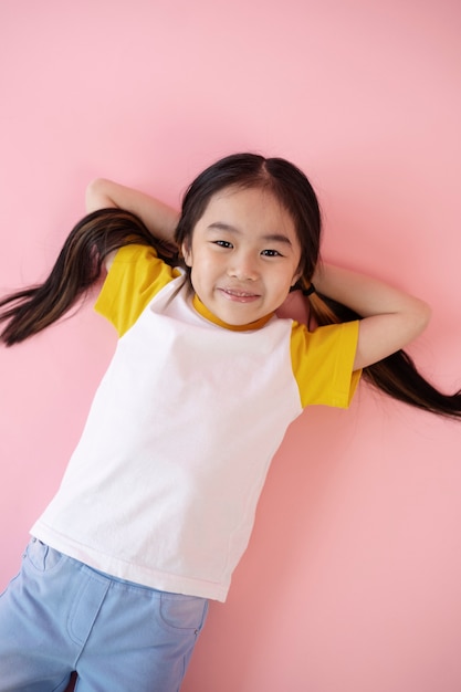 Ragazza asiatica posa sul pavimento rosa