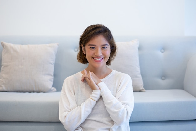 Ragazza asiatica positiva felice circa l&#39;interno accogliente della sua casa