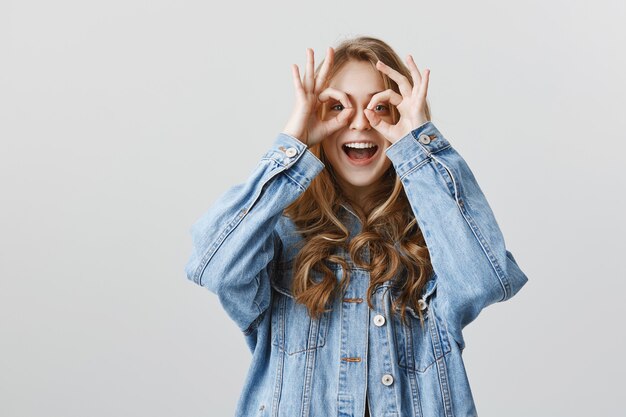 Ragazza attraente allegra che mostra il gesto giusto, nessun problema, ben fatto, eccellente