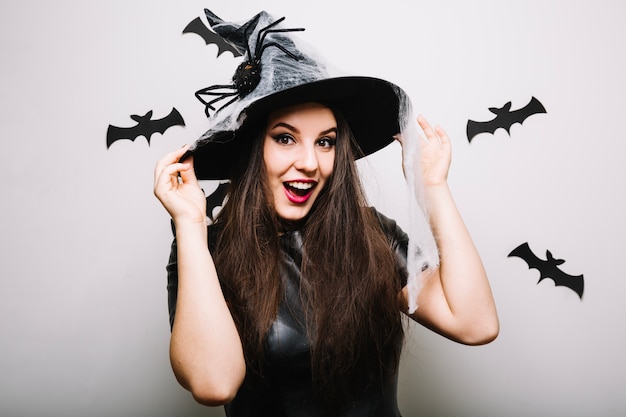 Ragazza attraente con cappello di Halloween in studio