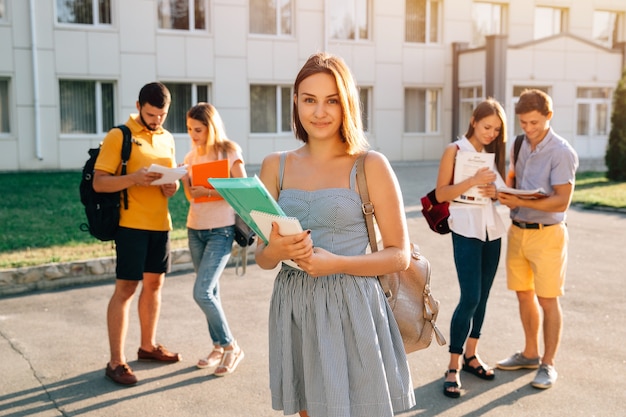 Ragazza bella con libri di tenuta zaino rosso velluto