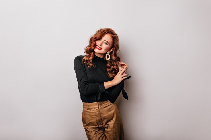 Foto gratuito ragazza bianca dai capelli lunghi carina in posa con il sorriso. splendida signora allo zenzero in camicetta nera che esprime felicità.