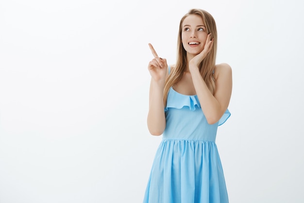 Ragazza bionda carina in vestito blu alla moda