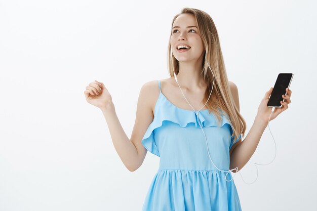 Ragazza bionda carina in vestito blu alla moda