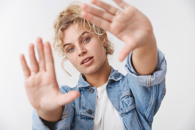 ragazza bionda che tira le mani alla telecamera