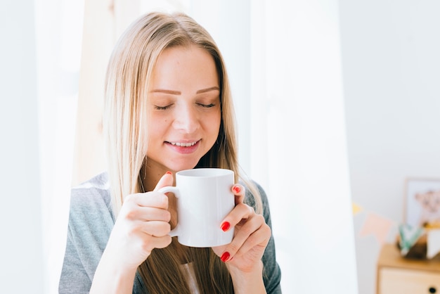 Ragazza bionda con caffè al mattino