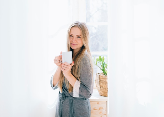 Ragazza bionda con caffè al mattino