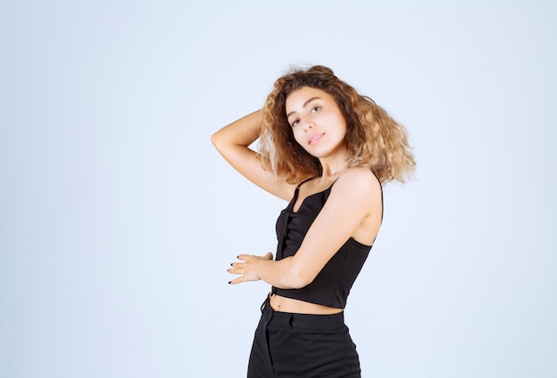 Ragazza bionda con i capelli ricci che dà pose positive e sorridenti.