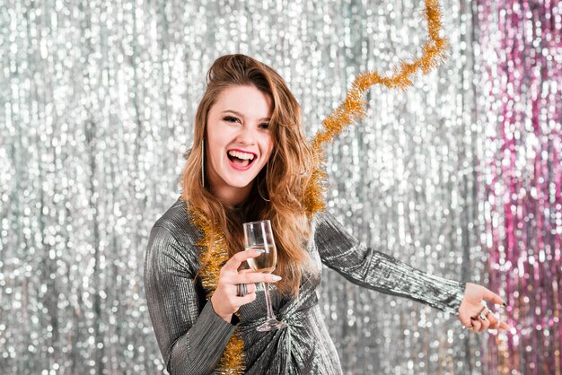 Ragazza bionda con il gioco del bicchiere di champagne