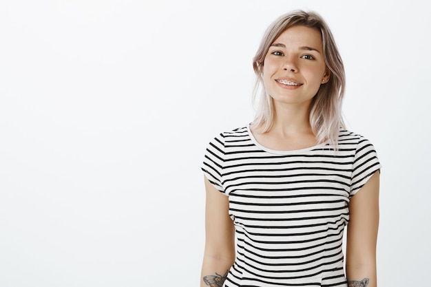 Ragazza bionda positiva in posa in studio