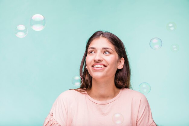 Ragazza bruna che gioca con le bolle di sapone