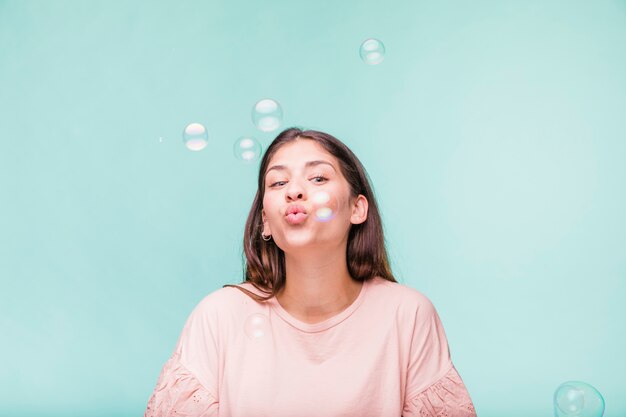 Ragazza bruna che gioca con le bolle di sapone