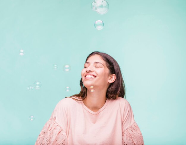 Ragazza bruna che gioca con le bolle di sapone