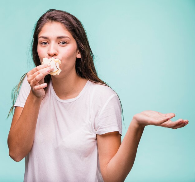 Ragazza bruna che mangia pasticceria