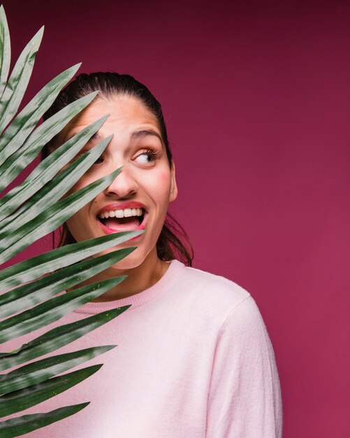 Ragazza bruna con foglia tropicale