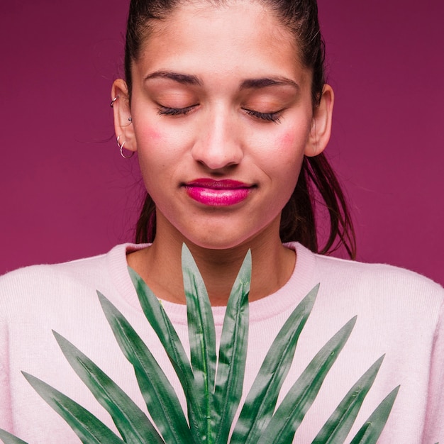 Ragazza bruna con foglia tropicale