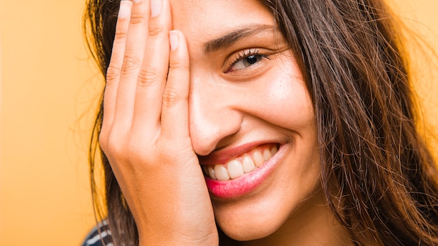 Ragazza bruna con la mano sul viso