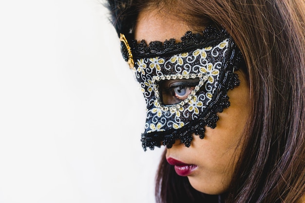 ragazza bruna con una maschera veneziana bianca