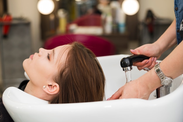 Ragazza bruna farsi lavare i capelli