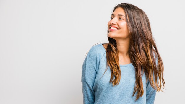 Ragazza bruna in posa con maglione blu