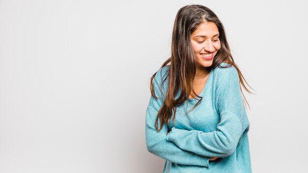 Ragazza bruna in posa con maglione blu