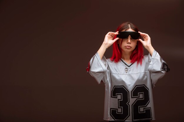 Ragazza capelli rosa in stile avantgarde indossando occhiali da sole.