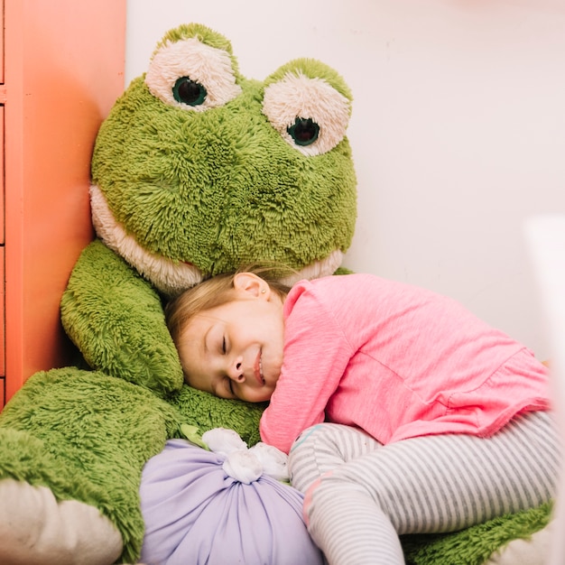 Ragazza carina che dorme con un peluche