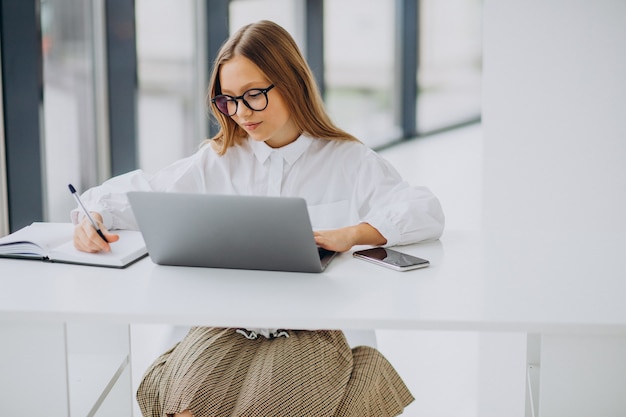 Ragazza carina che studia sul computer a casa