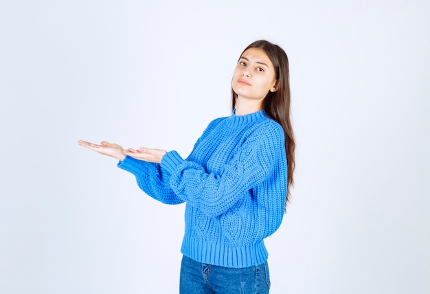 ragazza carina che tiene spazio aperto su bianco.