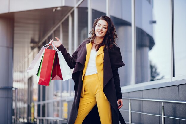 Ragazza carina con shopping bag in una città