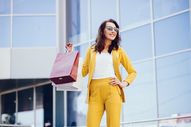 Ragazza carina con shopping bag in una città