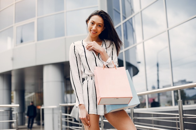 Ragazza carina con shopping bag in una città